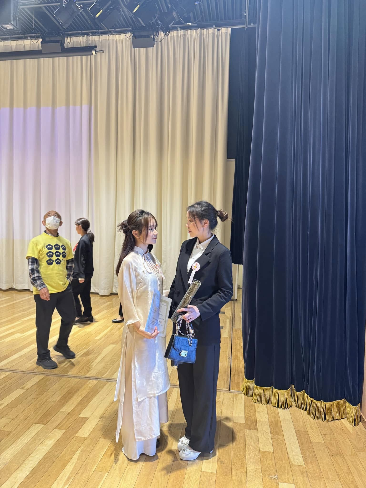 Two Women Talking on Stage at Graduation Event — © SIGIL